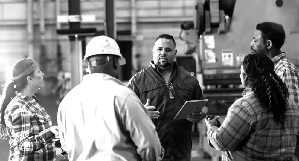 A supervisor leading a huddle on the plant floor