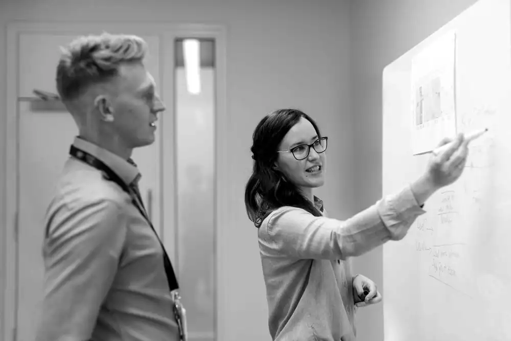 Colleagues working through a whiteboard session